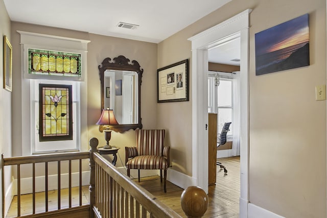 living area with visible vents, wood finished floors, and baseboards