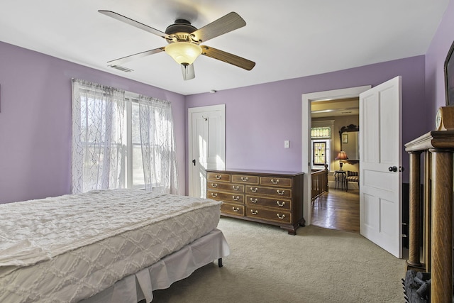 carpeted bedroom with multiple windows, ceiling fan, and visible vents