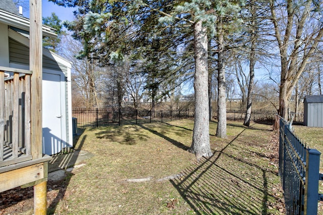 view of yard featuring a storage unit, an outdoor structure, and a fenced backyard