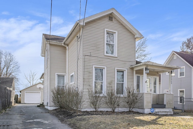 traditional home with an outbuilding, driveway, a detached garage, and fence