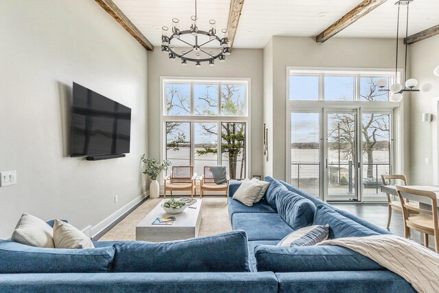 7505 S Lakeshore Dr, Pentwater, MI 49449 - living room featuring baseboards, a chandelier, a high ceiling, beam ceiling, and wood ceiling