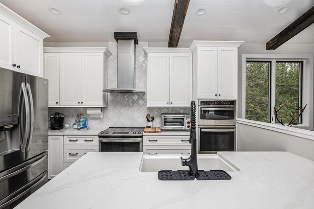 7505 S Lakeshore Dr, Pentwater, MI 49449 - kitchen with backsplash, white cabinets, wall chimney exhaust hood, beamed ceiling, and appliances with stainless steel finishes