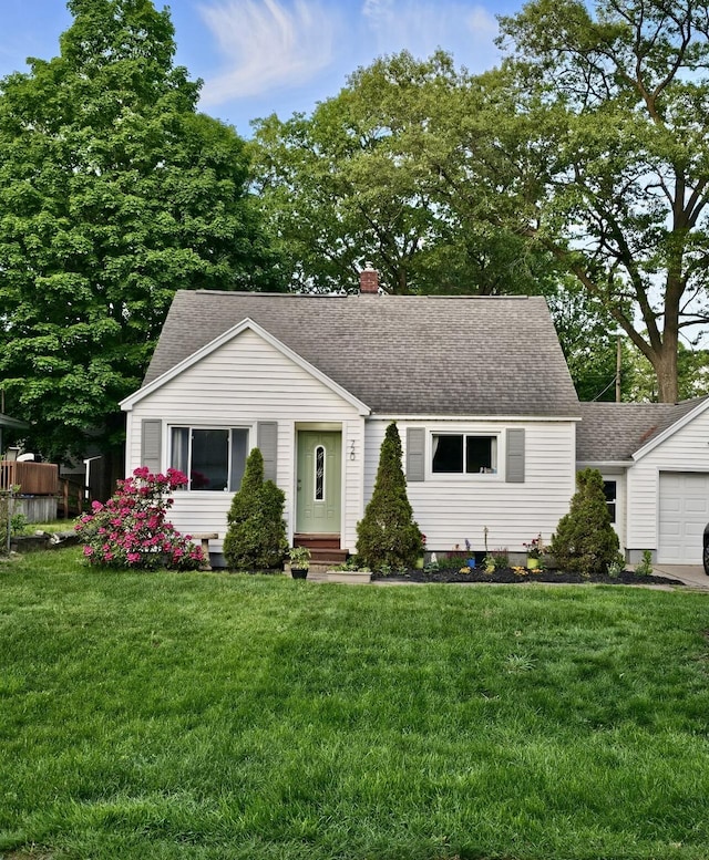 view of front facade featuring a front yard, roof with shingles, a chimney, entry steps, and a garage