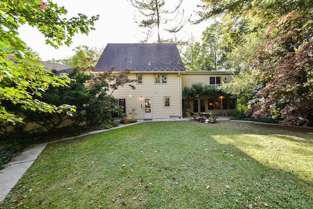 back of property featuring a yard and a patio area