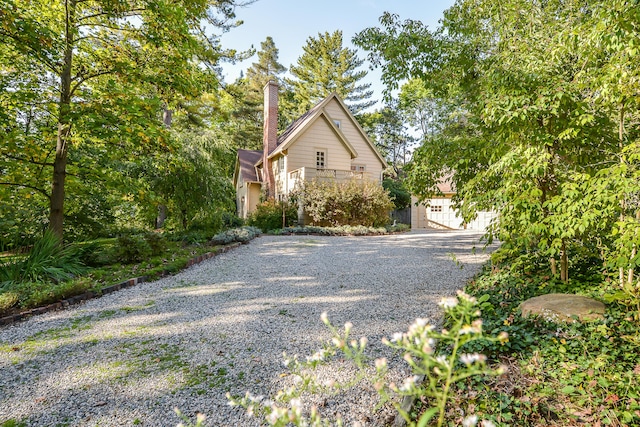 exterior space featuring driveway and a chimney