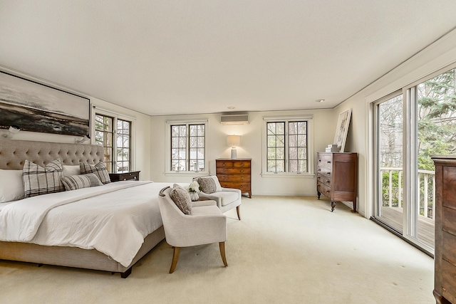 bedroom with access to outside, an AC wall unit, and light colored carpet