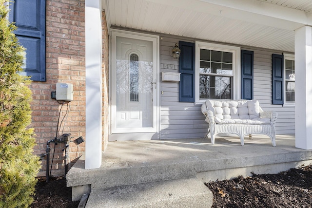 property entrance with brick siding and covered porch