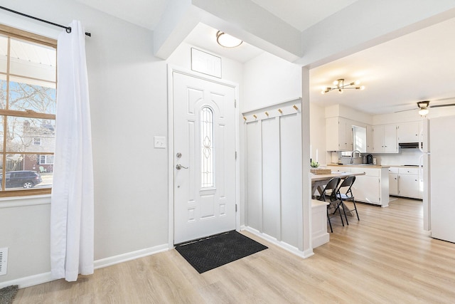 entrance foyer featuring visible vents, baseboards, light wood-style floors, and a ceiling fan