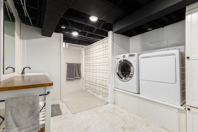 laundry room with a sink, laundry area, and washer and clothes dryer