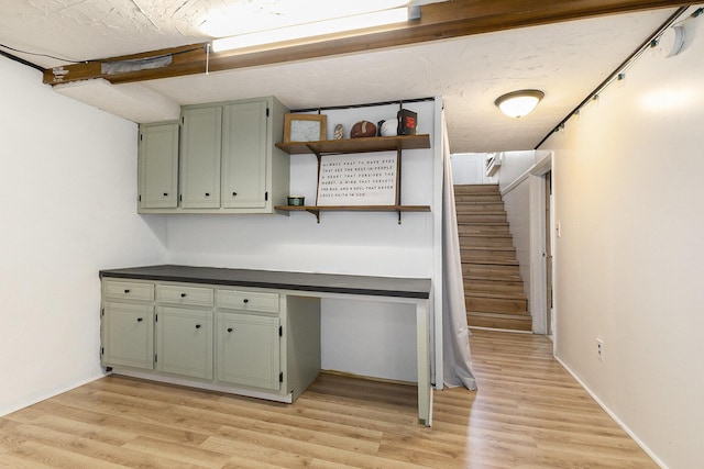 interior space featuring dark countertops, built in desk, light wood-style floors, and open shelves