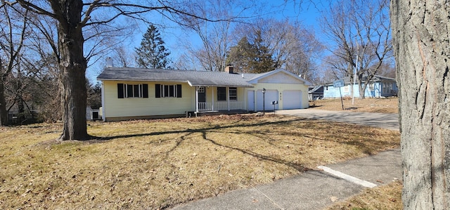 ranch-style home with a porch, concrete driveway, a front yard, a chimney, and an attached garage