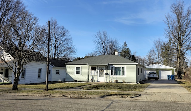 view of front of home with a garage, an outbuilding, roof with shingles, and a chimney