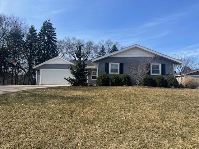 ranch-style home with a garage, driveway, and a front yard