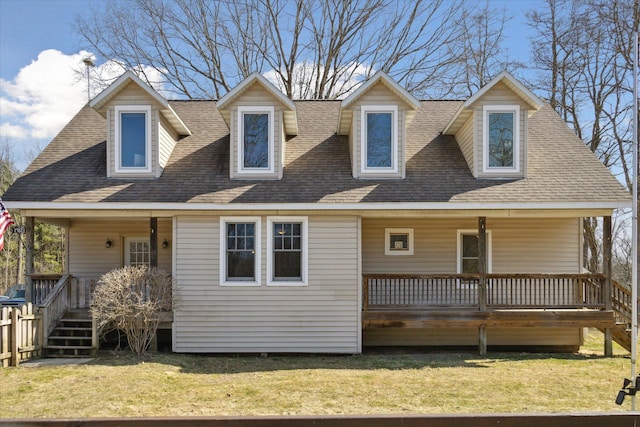 view of front facade with a porch, a front lawn, and roof with shingles