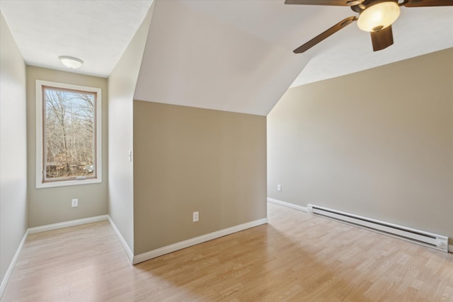 additional living space featuring lofted ceiling, light wood-style flooring, baseboards, and baseboard heating