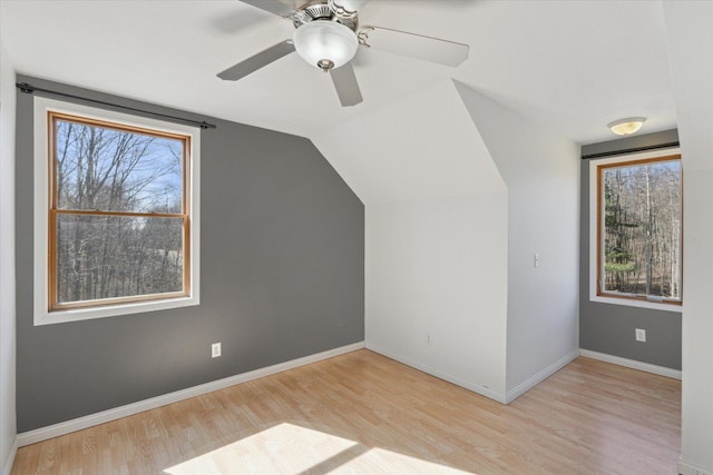 bonus room featuring baseboards, plenty of natural light, wood finished floors, and vaulted ceiling