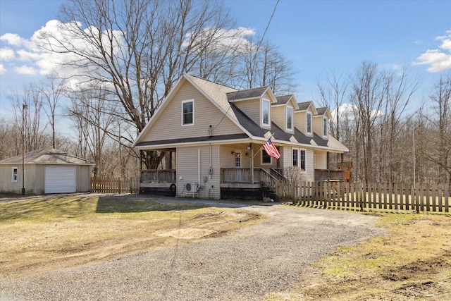 view of front of house with fence, dirt driveway, covered porch, a garage, and an outbuilding