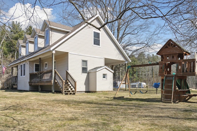 back of property featuring a lawn, a shingled roof, and a playground