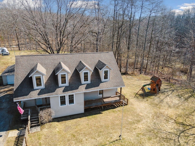 view of front facade with roof with shingles and a front lawn