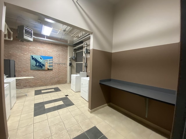 bathroom with washer and dryer, heating unit, brick wall, and tile patterned floors