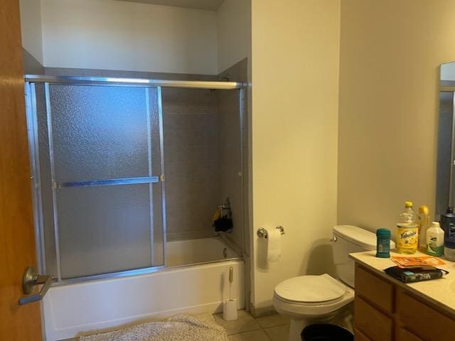 bathroom featuring tile patterned floors, vanity, toilet, and enclosed tub / shower combo