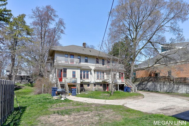 186 W 12th St, Holland, MI 49423 - rear view of house with a chimney, fence, a balcony, and stairs