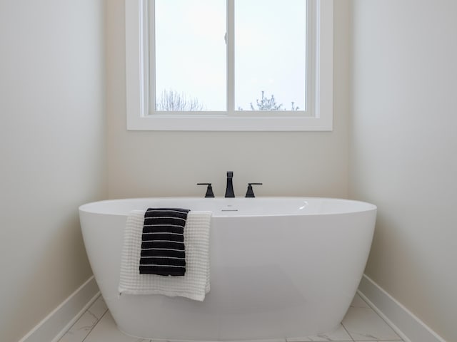 2613 Ashford Trl, Portage, MI 49024 - bathroom featuring baseboards, marble finish floor, and a freestanding bath