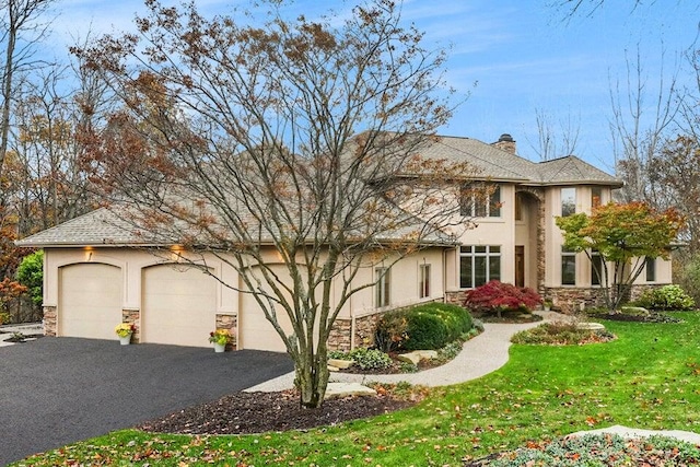 view of front of home featuring stucco siding, a front lawn, aphalt driveway, stone siding, and a garage