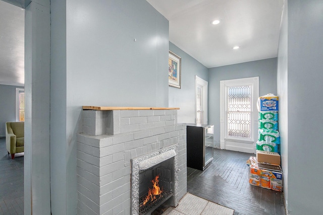 living area featuring baseboards, recessed lighting, and a brick fireplace
