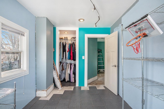 unfurnished bedroom with track lighting and a closet