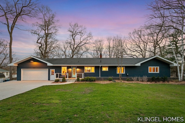 ranch-style home with a chimney, an attached garage, driveway, and a yard