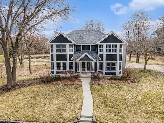 view of front of home featuring a chimney, a front lawn, french doors, and roof with shingles