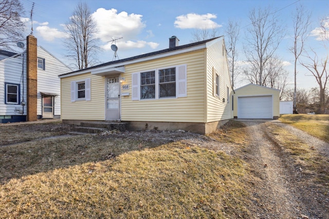 view of front of home with an outbuilding, driveway, entry steps, a detached garage, and a chimney