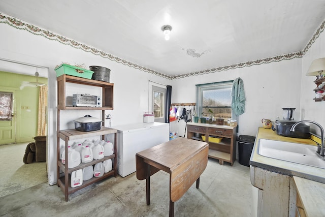 home office featuring a sink and concrete floors