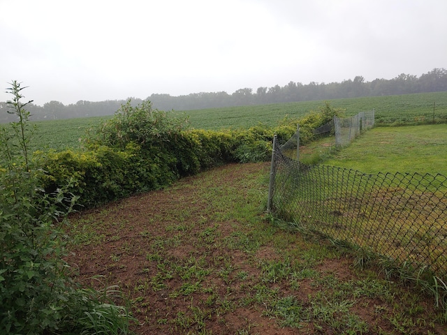 view of yard with a rural view and fence
