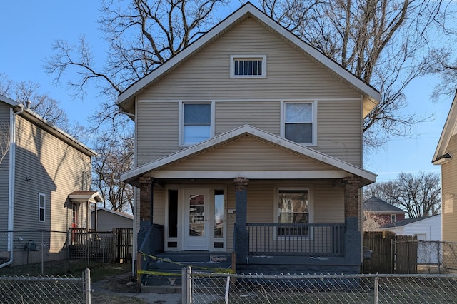 traditional style home featuring a porch, a gate, and a fenced front yard