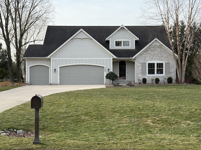 craftsman-style house with a front yard, a shingled roof, concrete driveway, a garage, and board and batten siding