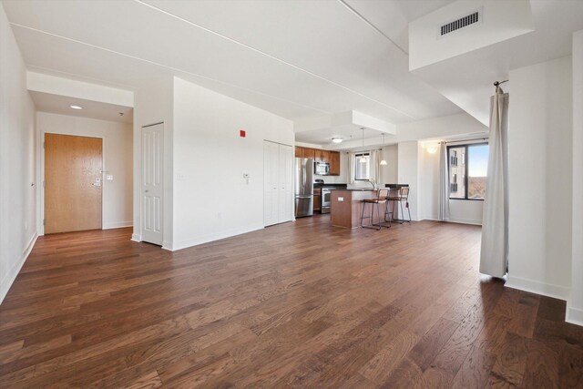 111 N Ashley St Unit 510, Ann Arbor, MI 48104 - unfurnished living room featuring dark wood finished floors, baseboards, and visible vents