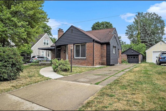 view of front of home featuring a front yard, an outdoor structure, concrete driveway, and brick siding