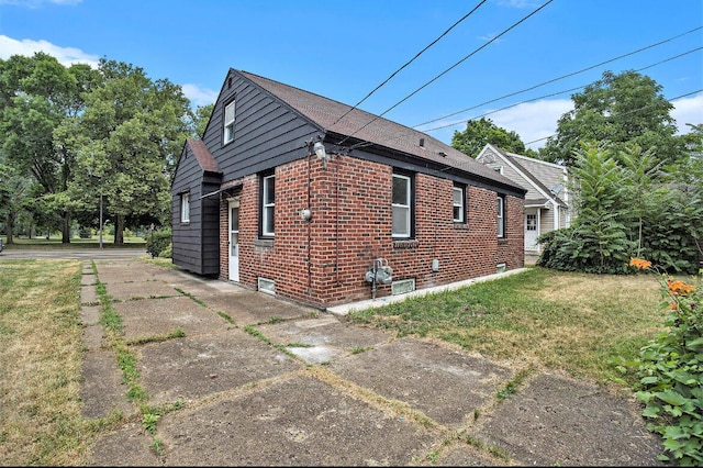 view of home's exterior featuring a yard and brick siding