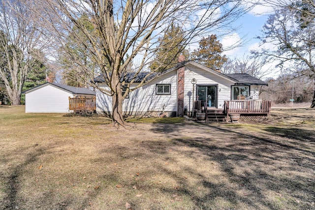 rear view of house with a wooden deck and a yard