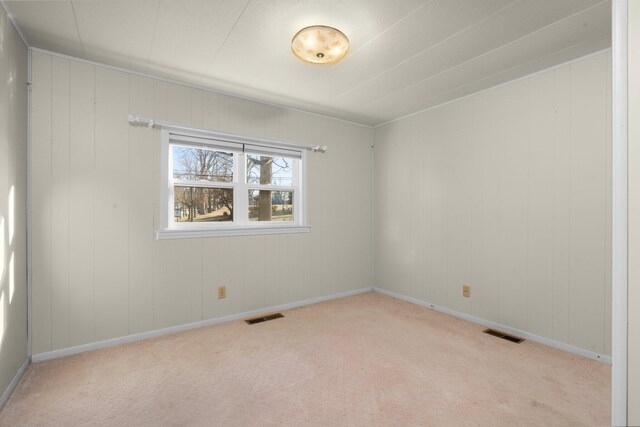 carpeted empty room with visible vents and baseboards
