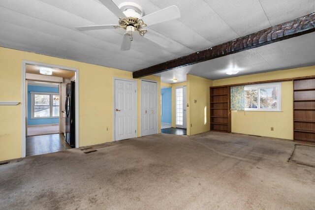interior space with visible vents, a ceiling fan, and freestanding refrigerator