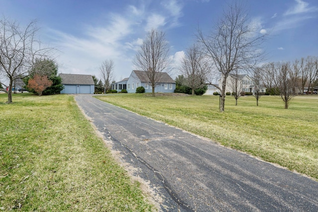 view of front of home with an outbuilding, a front yard, and driveway