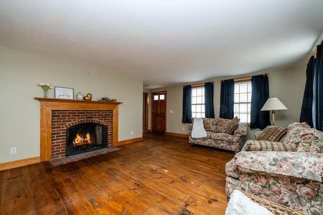 living room with a brick fireplace, baseboards, and wood-type flooring