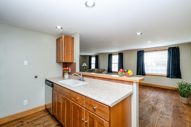 kitchen featuring dark wood-type flooring, a sink, open floor plan, a peninsula, and dishwasher