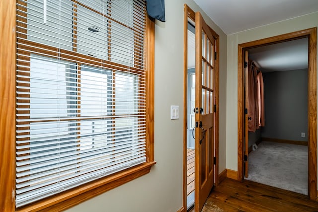 hallway with baseboards and wood finished floors