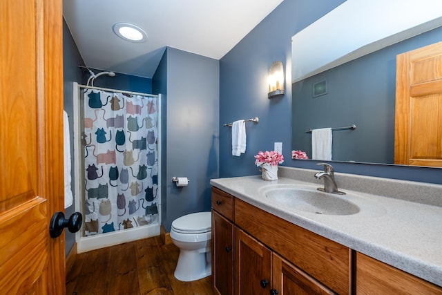 bathroom featuring vanity, a shower with shower curtain, wood finished floors, baseboards, and toilet