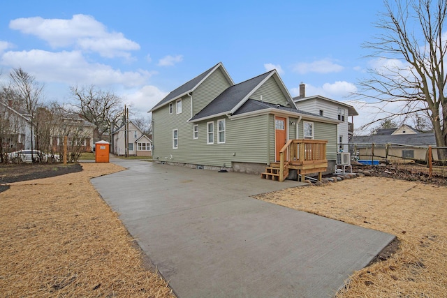 609 Lincoln Ave NW, Grand Rapids, MI 49504 - view of side of property featuring driveway, a shingled roof, and a chimney