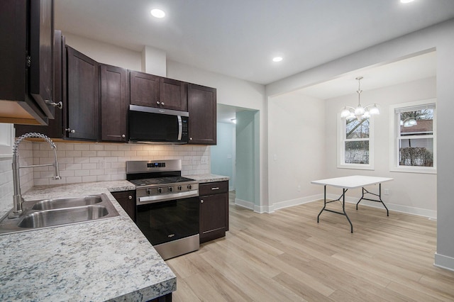 609 Lincoln Ave NW, Grand Rapids, MI 49504 - kitchen with appliances with stainless steel finishes, dark brown cabinets, light countertops, decorative backsplash, and recessed lighting
